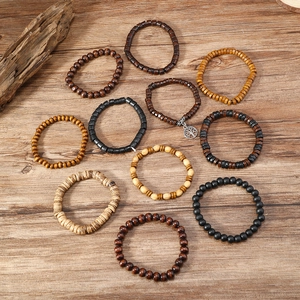 Detail view of 10-piece natural wood bead bracelet set with tree of life charm and elastic cord