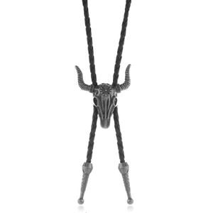 Vintage bull skull bolo tie with star and floral engravings on black braided cord