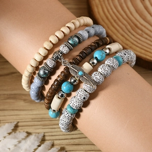 Bohemian multi-layer turquoise beaded bracelet set featuring a metallic feather charm