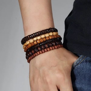 Close-up of stacked vintage wooden bead bracelets with natural grain on male wrist