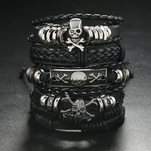 Detail of multi-layer black braided leather bracelets with silver skull charms