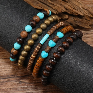 Close-up of a 5-piece turquoise and wooden beaded bracelet set on a vintage wood display