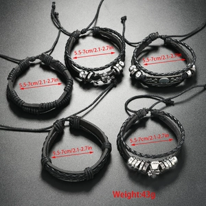 Close-up of five black braided PU leather men's bracelets with adjustable skull charms