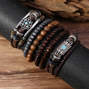 Détail de bracelets bohèmes multicouches avec perles de bois, cuir tressé et breloques vintage