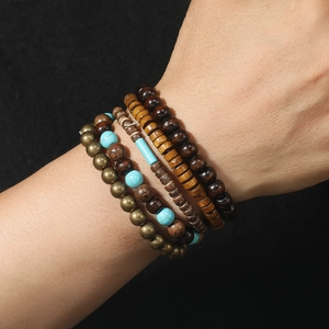 Close-up of stacked turquoise beads and wooden bead bracelets on wrist in retro style