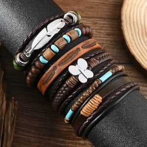 Detail eines mehrlagigen Boho-Armbands mit Türkisperlen und Federanhänger im Vintage-Stil