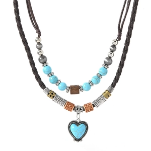 Detail of bohemian heart turquoise pendant necklace with woven cord and vintage beads