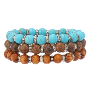 Detail of bohemian turquoise beads and wooden bead layered bracelets with crystal spacers