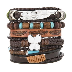 Detail von Boho-Armbändern mit Türkisperlen und silbernen Schmetterlingsanhängern
