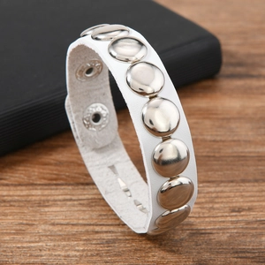 Detail view of white leather punk bracelet with round silver rivets and snap buttons