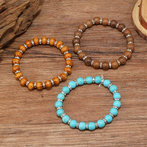 Macro detail of turquoise and wood beaded bracelets with crystal-set silver spacer beads
