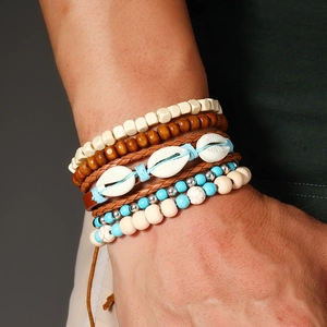 Détail de bracelets bohèmes superposés avec perles turquoise et breloques en coquillage