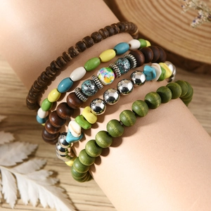 Detailed view of bohemian turquoise bead bracelet set on a model's wrist with wood background