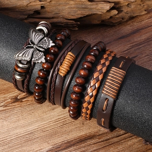 Détail de bracelets multi-rangs bohèmes en cuir avec perles de bois et breloque papillon
