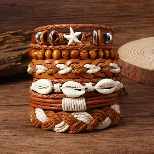 Détail de bracelets bohèmes superposés avec perles, coquillages et étoiles de mer