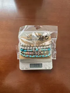 Detail of bohemian turquoise and wooden bead bracelet on a scale showing 32.9g weight