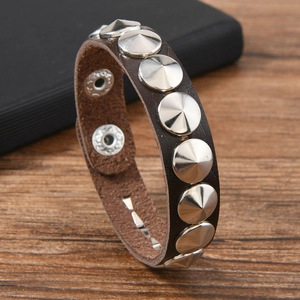 Détail macro du bracelet punk en cuir marron avec rivets métalliques coniques argentés