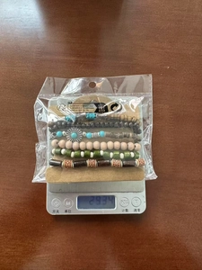 Close-up of bohemian multilayer beaded bracelet weight measurement on digital scale
