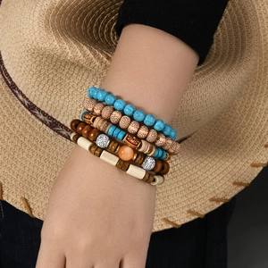 Detail view of multi-layer bohemian turquoise bead bracelets worn on a wrist