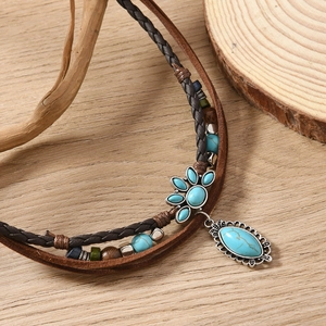 Bohemian multilayer turquoise necklace with vintage beads and pendant on wood background