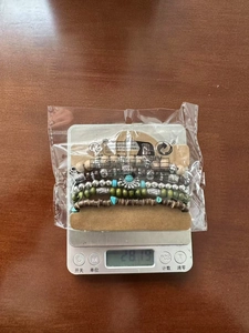 Detailansicht eines böhmischen Türkis- und Holzperlenarmband-Sets auf einer Digitalwaage