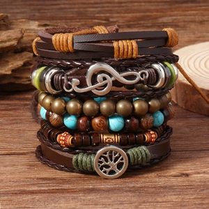 Nahaufnahme von mehrlagigen Boho-Armbändern mit Lebensbaum- und Notenschlüssel-Anhängern