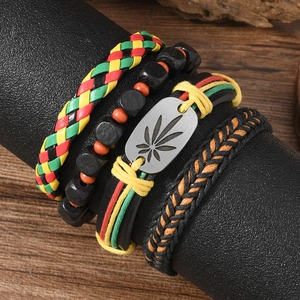 4-piece Jamaica style men's leather bracelet set with maple leaf charm on a black stand