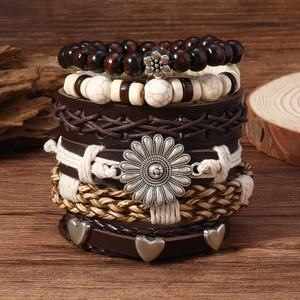 Détail d'un ensemble de bracelets bohèmes multicouches avec marguerite et cuir