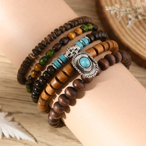 Detail of layered turquoise and wooden bead bracelets with bohemian vintage charms