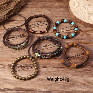 Detail von mehrlagigen Boho-Armbändern mit Türkisperlen, Lebensbaum- und Musiknoten-Anhängern