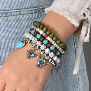Bracelet multicouche bohème avec pendentifs cactus et taureau porté sur le poignet