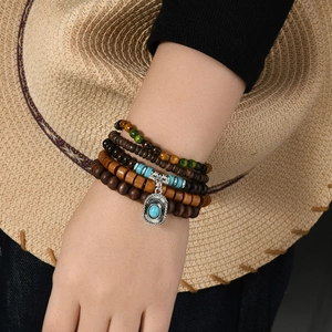 Detail of bohemian layered beaded bracelet set with turquoise and cowboy hat charm