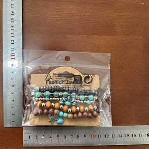 Detail view of multi-layer Bohemian beaded bracelets with measurement scale on wood background
