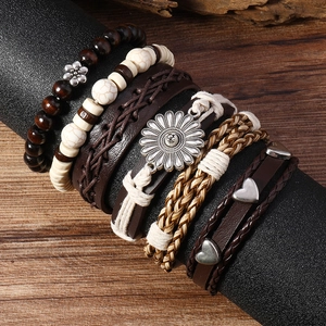 Détail de bracelets bohèmes multicouches avec perles en bois, cuir et breloques de fleurs
