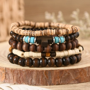 Detail of bohemian layered wooden bead bracelet set with turquoise accents and a cross charm
