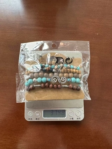 Détail d'un bracelet multicouche bohème avec perles en bois et breloque symbole infini