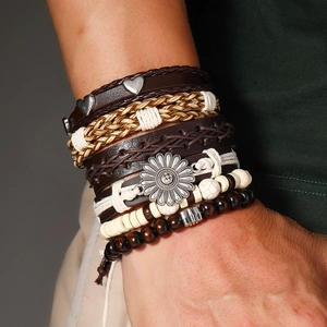 Gros plan de bracelets bohèmes avec lanières en cuir et breloques de tournesol