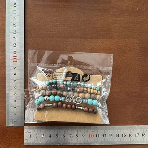 Détail d'un lot de 4 bracelets multicouches en perles de bois avec accents turquoise