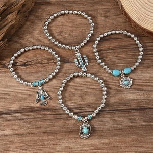 Set of four bohemian stretch bracelets with turquoise beads and vintage metal charms
