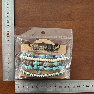 Detail of five-layer bohemian beaded bracelet set with turquoise, wood beads and metal charms