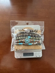 Detail showing five-piece beaded leather bracelet set weighed on digital scale