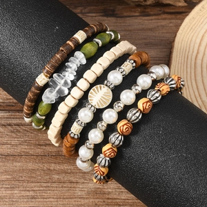 Bohemian multilayer beaded bracelet set with wood beads and sun charm on a display