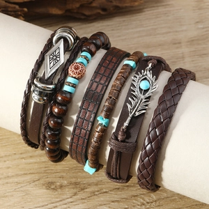 Détail de bracelets bohèmes multicouches en cuir avec perles turquoise et plumes