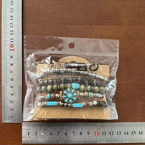 Detail of bohemian leather bracelet set with turquoise sunflower and wooden beads