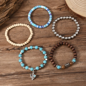 Five-piece set of bohemian beaded bracelets with turquoise and cactus pendant on wood