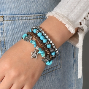 Bohemian multilayer turquoise beaded bracelet with silver butterfly charm on wrist