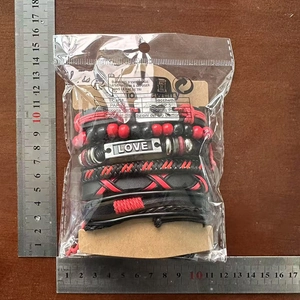 Detailed view of woven leather bracelets with LOVE charms next to measuring rulers