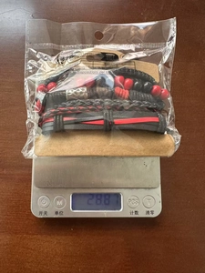 Detailed view of woven leather bracelets with beads on a digital scale for weight display