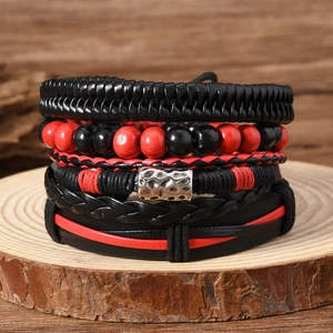 Layered vintage braided leather bracelet with red and black beads on a wooden stand
