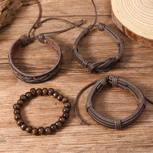 Vintage men brown leather woven bracelet set with wooden beads on wooden background